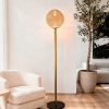 Podna lampa Vinta Gold sa dimljenim staklenim sjenilom u modernom dnevnom boravku